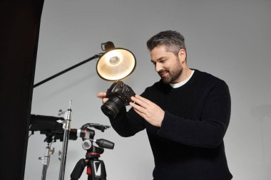 Yetenekli bir profesyonel güzel anları yakalamak için kamerasını iyi aydınlatılmış bir stüdyoya yerleştirir..