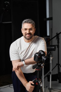Yetenekli bir adam ışıklarla dolu iyi donanımlı bir fotoğraf stüdyosunda anları yakalar..