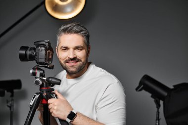 Modern bir fotoğraf stüdyosunda ekipman kurarken kendini işine adamış profesyonel bir gülümseme..
