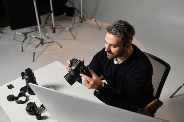 A man checks his camera settings amidst photography gear, ready for a session.