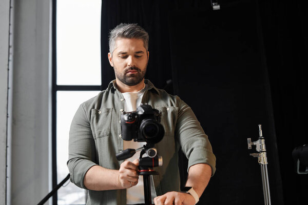 A skilled person sets up a camera to capture creative moments in a bright studio.