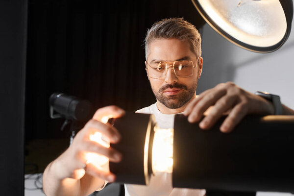 Man prepares lighting equipment meticulously, ensuring optimal conditions for captivating visuals.