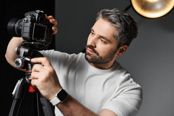 Focused individual fine tuning camera equipment in a stylish studio setting before a shoot.