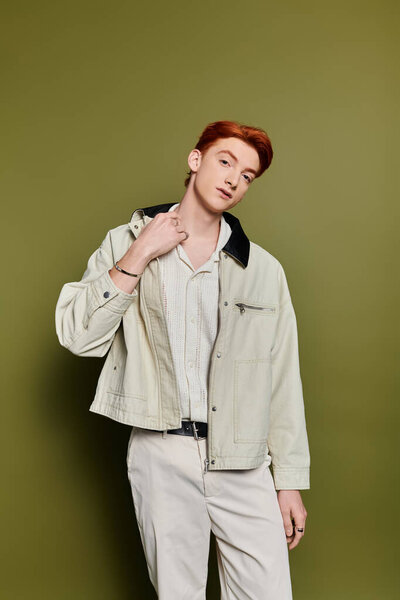 A handsome young man with striking red hair shows emotion through his confident pose.