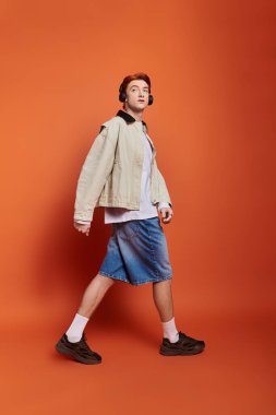 Genç, yakışıklı bir adam, kentli kıyafetiyle duygularını sergileyerek kendine güvenerek adımlar atar..