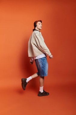 Genç ve yakışıklı bir adam coşkuyla yürür, modern modayı canlı bir mekanda sergiler..