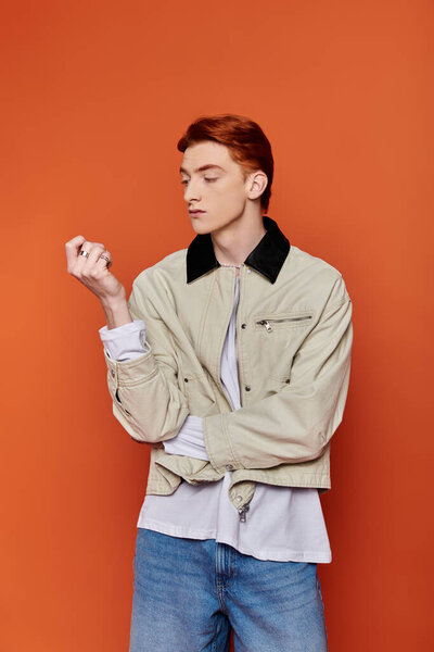 A handsome young man poses confidently, expressing deep emotion against a striking backdrop.