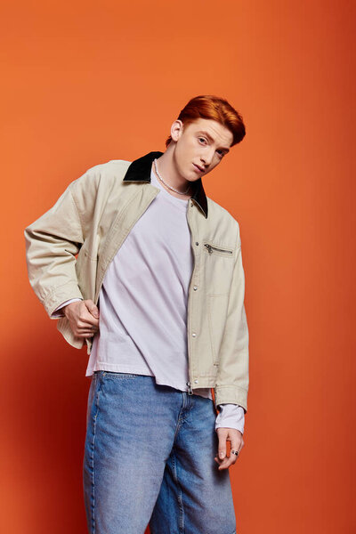 A young and handsome man showcases his emotional expression while posing in casual attire.