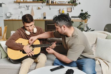 İki kardeş, sıcak ve davetkar bir yerde gitar çalmayı öğrenerek bir anın tadını çıkarıyorlar..