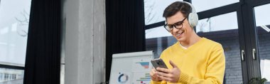 New employee embraces technology, smiling and engaged while onboarding in a modern workspace. clipart