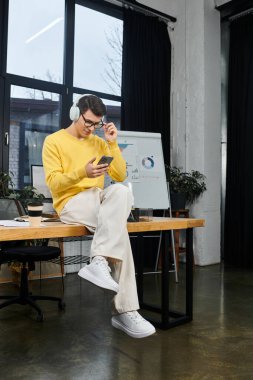 Heyecanlı yeni çalışan ilk gün modern ofis ortamında akıllı telefona bağlanıyor.