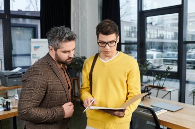 İki meslektaş, parlak bir sabahta ofiste borda materyallerini tartışıyor..