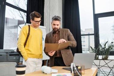 A mentor helps a new team member review important documents at work on their first day. clipart