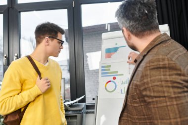 Yeni işe alınan kişi, parlak bir ofiste sunulan malzemeleri dikkatle dinliyor..