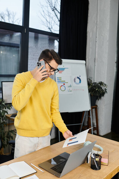 New employee connects with colleagues over the phone while reviewing documents on their first day.