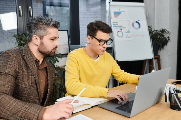 Two colleagues work together on the first day of a new job in a contemporary office space.