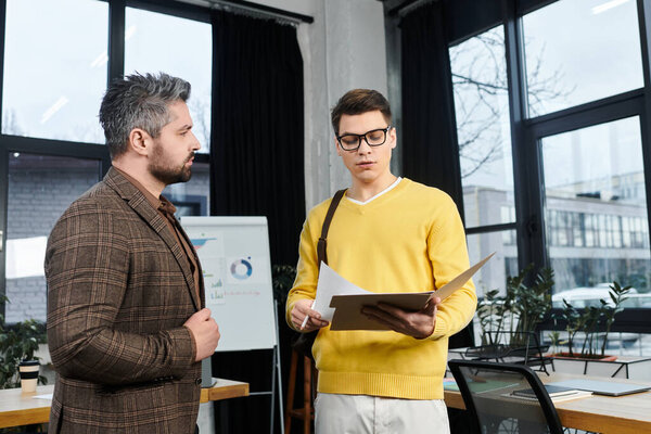 New employee discusses onboarding details with a colleague in a bright office setting.