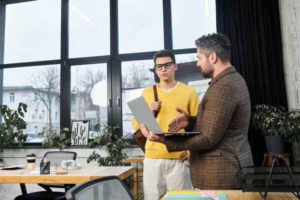 Two colleagues engage in a discussion while onboarding a new employee in a stylish office setting.