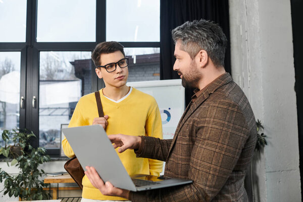 Two colleagues engage in conversation on the first day of work, sharing insights and knowledge.
