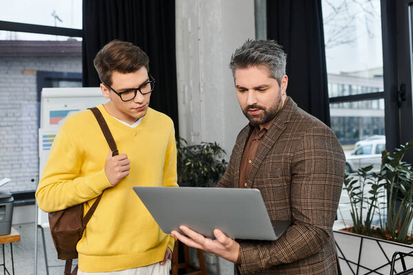 A young professional is learning the ropes from his manager on the first day of work in the office.