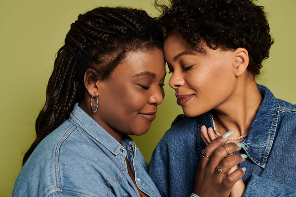 Two fashionable women embrace each other, radiating love and joy in a trendy setting.