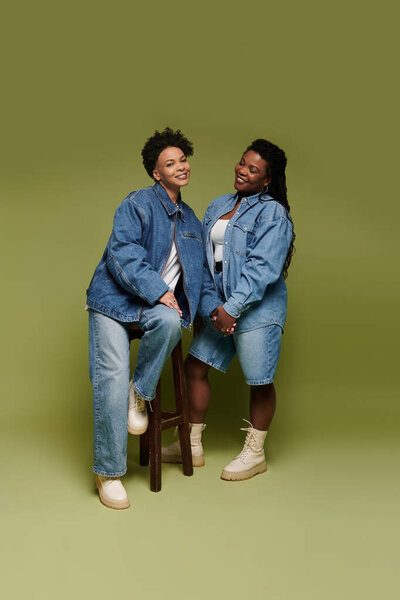 Радостная лесбийская пара демонстрирует свои шикарные джинсовые наряды в стильной студии.