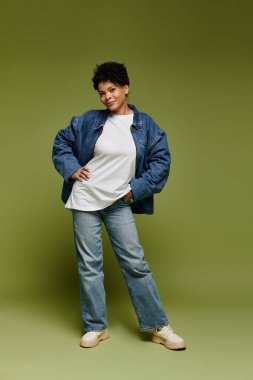 Yeşil zeytin arkaplanda poz veren canlı giyinmiş şık bir kadın..