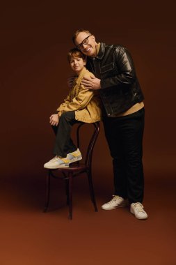 Günlük giysiler içinde bir baba ve oğul sıcak bir stüdyoda kahkaha dolu bir anı paylaşıyorlar..