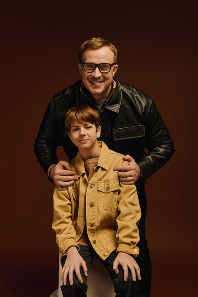 Гордый отец разделяет радостный момент в подходящих нарядах со своим сыном.