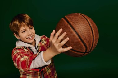 Kareli kıyafetli enerjik çocuk bir basketbol topuyla karşılaşır ve neşe saçar..