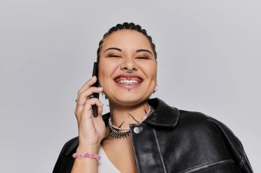 Parlak bir gülümsemesi olan genç bir kadın canlı bir telefon görüşmesi yapar ve tarzını gösterir..