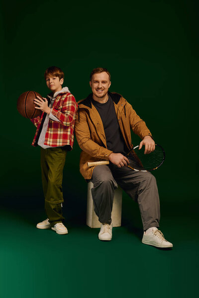 Веселый отец и сын позируют вместе в модной повседневной одежде, демонстрируя свою связь.