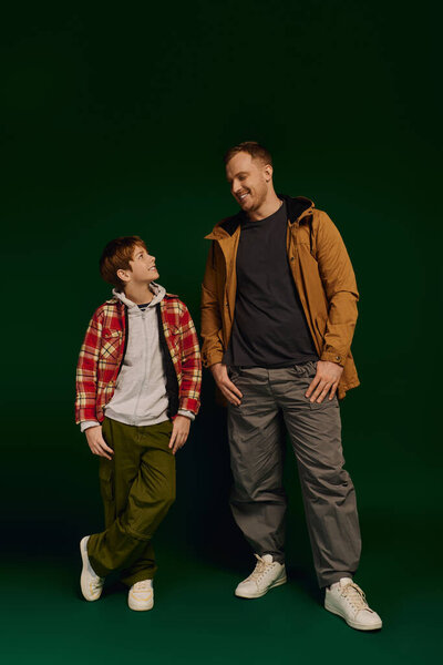 Счастливый отец и его сын наслаждаются друг другом, одеваясь в модную повседневную одежду..