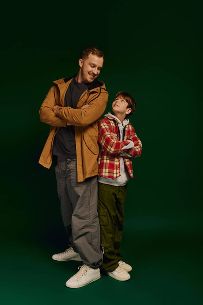 Радостный отец и сын позируют вместе в повседневной одежде, демонстрируя свою семейную связь..