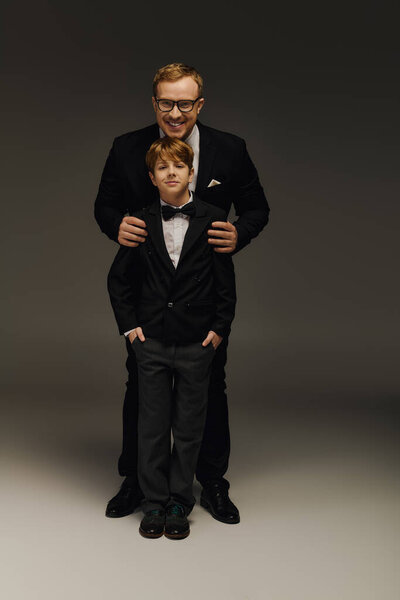 Красивый отец и сын позируют вместе в элегантных галстуках-бабочках, демонстрируя утонченность.