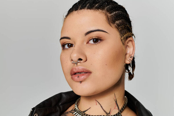 A young woman with braided hair and distinctive piercings exudes confidence in her fashion choices.