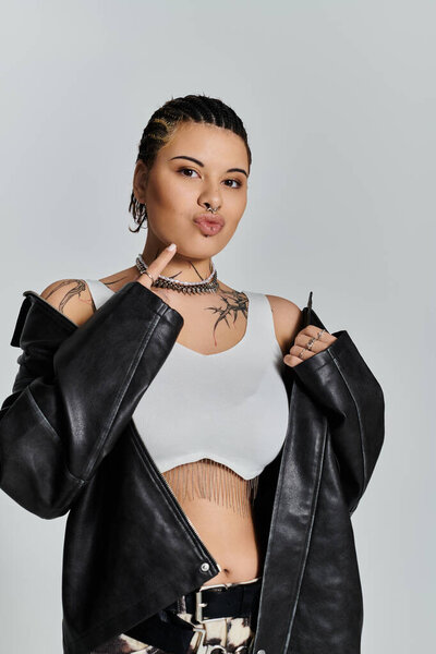 Очаровательная молодая женщина демонстрирует свое чувство стиля с смелым позой и отчетливым стилем в студии.