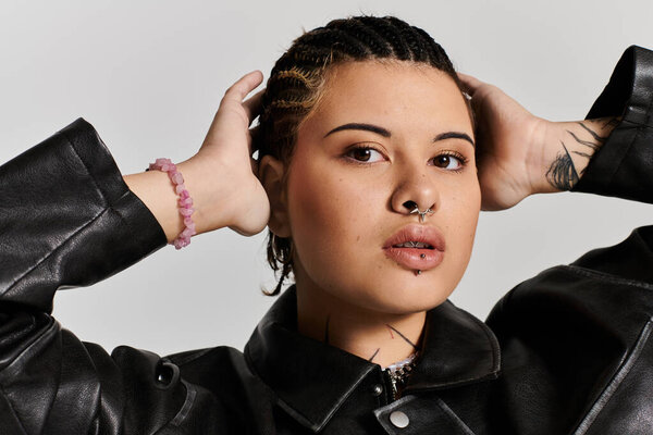 Confident young woman in a leather jacket poses, showcasing her style and individuality.