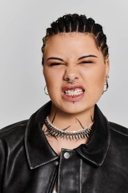 Kendine güvenen genç bir kadın cesur moda tarzını sergilerken aynı zamanda sinirli bir tavır sergiliyor..