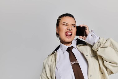 Genç bir kadın telefonda konuşuyor. Benzersiz tarzını ve özgüvenini gösteriyor..