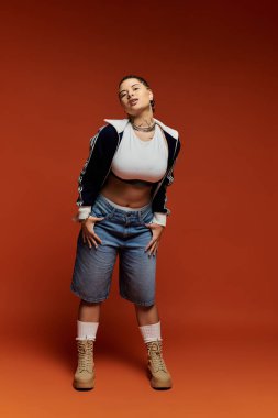 Şık bir genç kadın kendine güvenen ve yetenekli şık bir kıyafet giyerek neşeli bir poz verir..