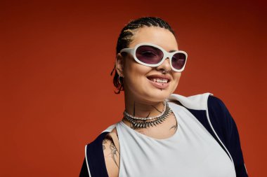 Kendine güvenen genç bir kadın moda ve eğlenceyi moda aksesuarları ve parlak bir gülümsemeyle somutlaştırır..