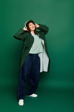 Güzel bir kadın mutluluğu neşeli bir poz ve rahat bir ortamda moda kıyafetlerle kutluyor..