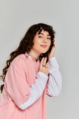 Tarz sahibi genç bir kadın hoş bir şekilde moda görünümünü sergilerken, duygular ve cazibe saçıyor..