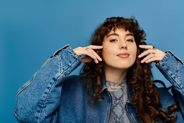 A stylish young woman expresses emotions through her bold pose and fashionable outfit.