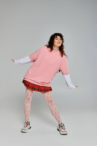 A young woman showcases her fashionable style while joyfully dancing in a bright studio.