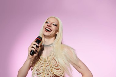 Şık bir travesti, canlı bir LGBTQ etkinliğinde gösteri yaparken herkesi büyülüyor..