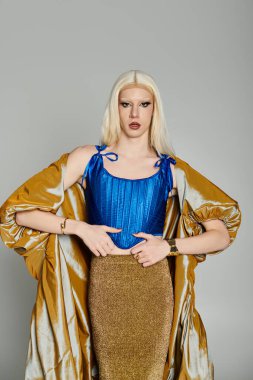 Bir travesti cesur mavi elbisesi ve pırıl pırıl altın eteğiyle cazibesine kapılır..