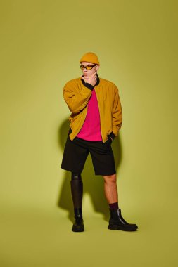 Protez bacaklı yakışıklı genç adam canlı bir arkaplan karşısında şık pozlar veriyor..