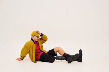 Protez bacaklı yakışıklı genç adam, modaya uygun giyinmiş, gösterişli pozlar veriyor..